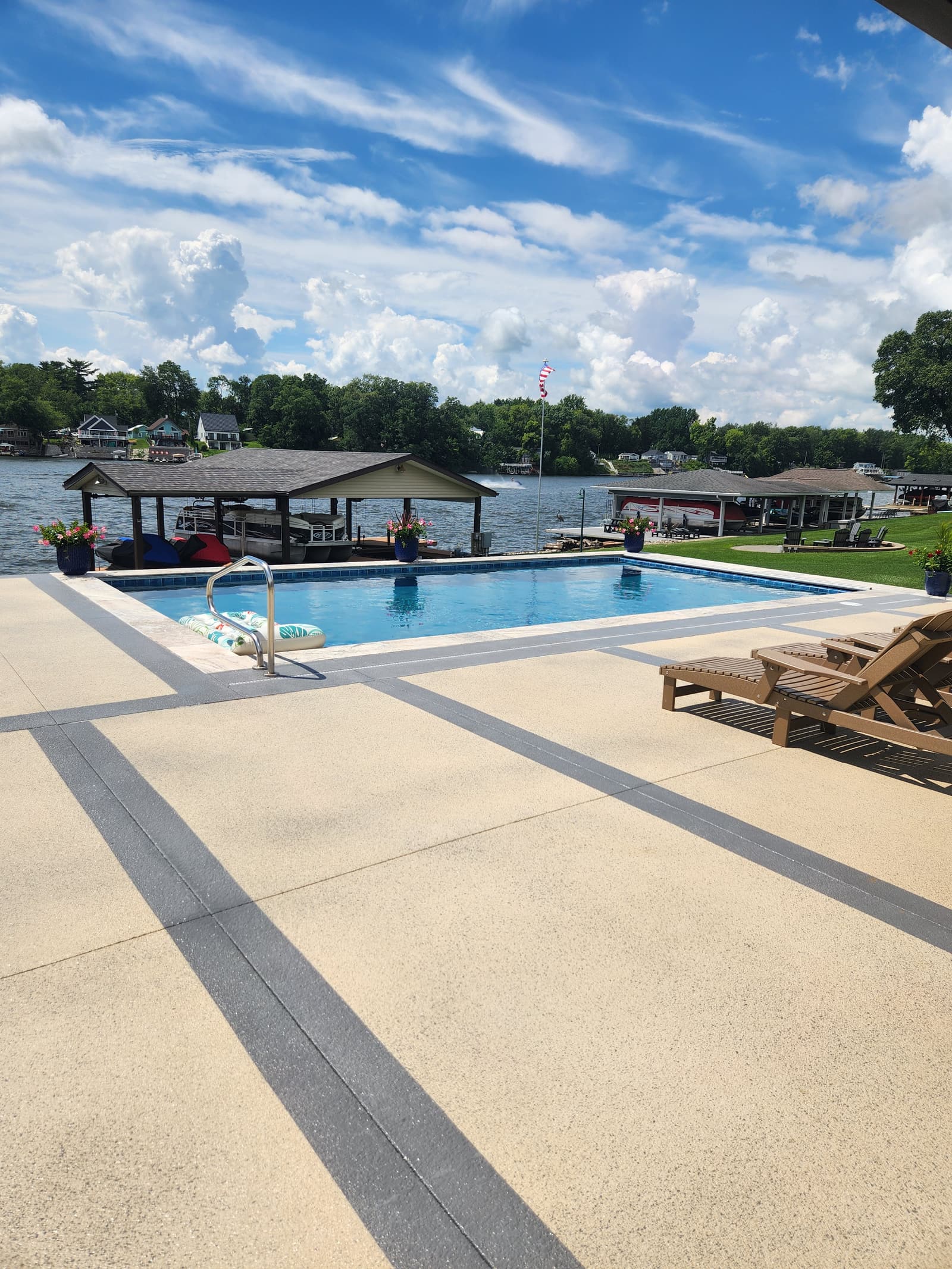 Lakeside pool with banded concrete deck and boat house