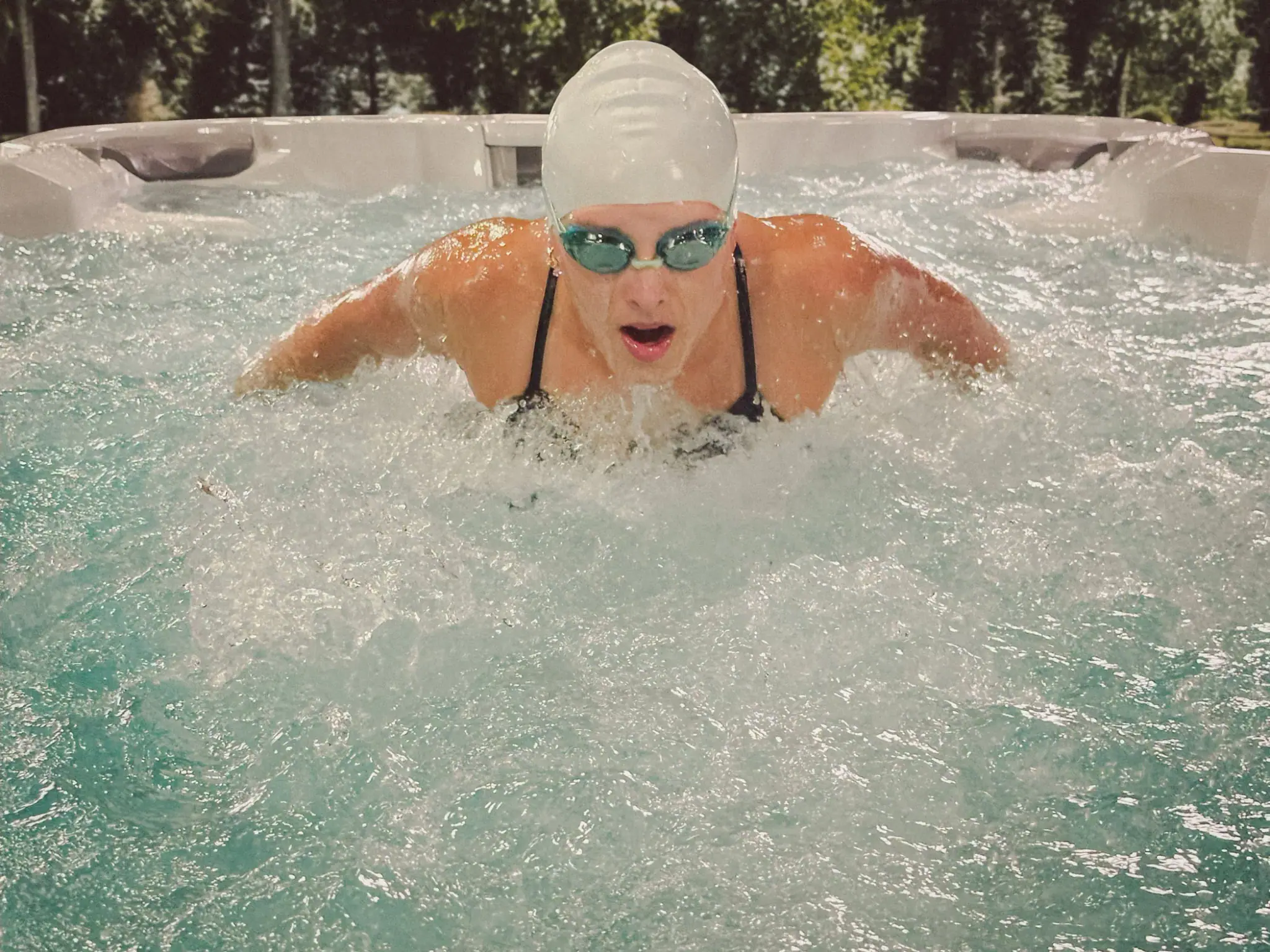 Swimmer training against the current in a swim spa