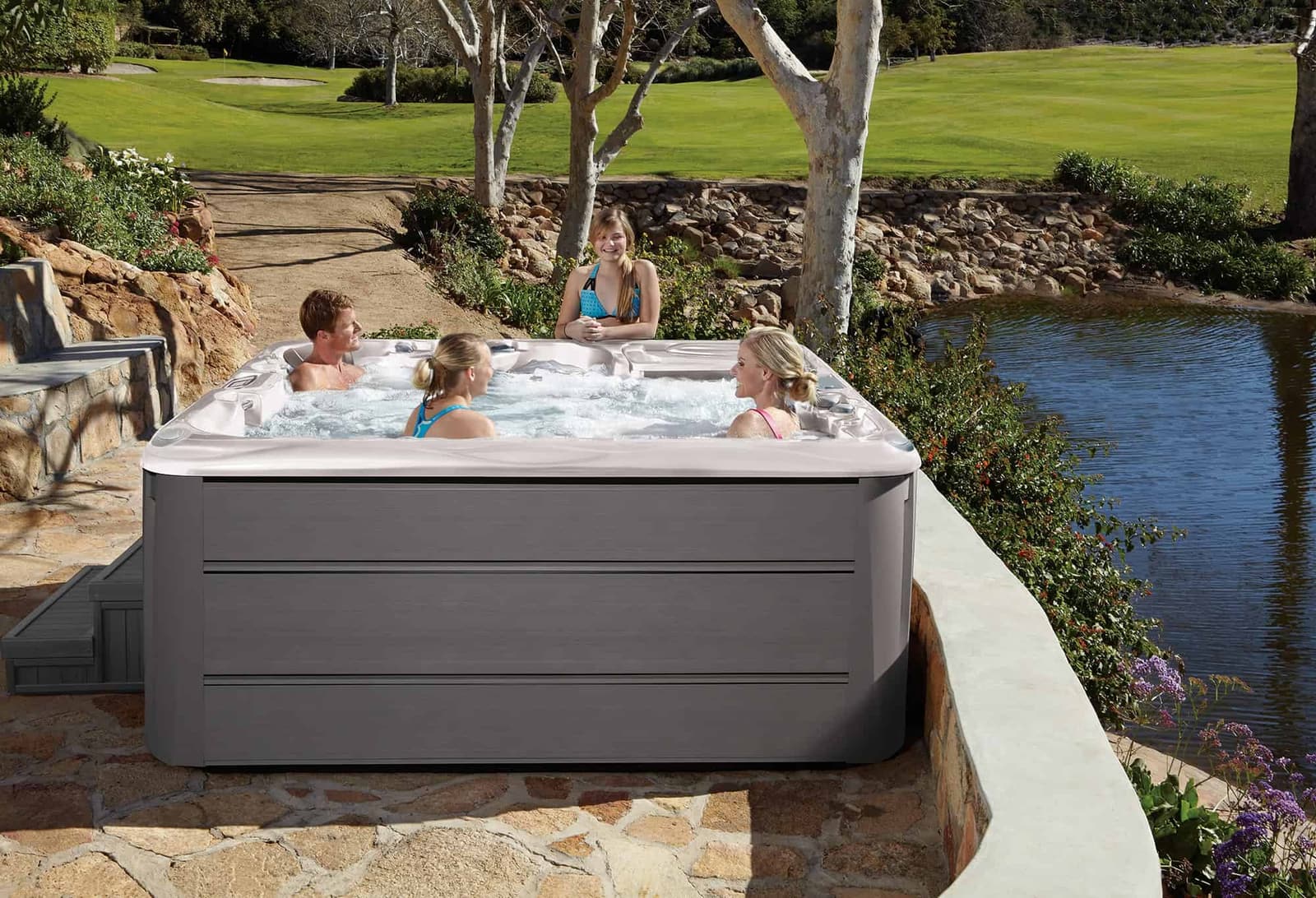 Family enjoying their Sundance Spas 880 Series Cameo by the water