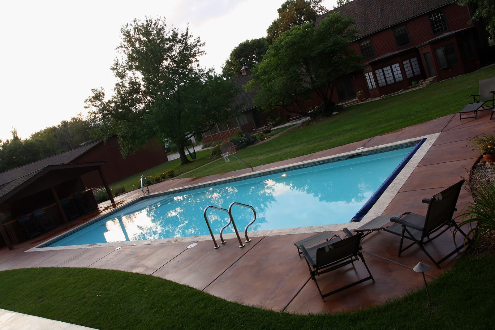 Pool edged with white marble coping and a stained concrete deck