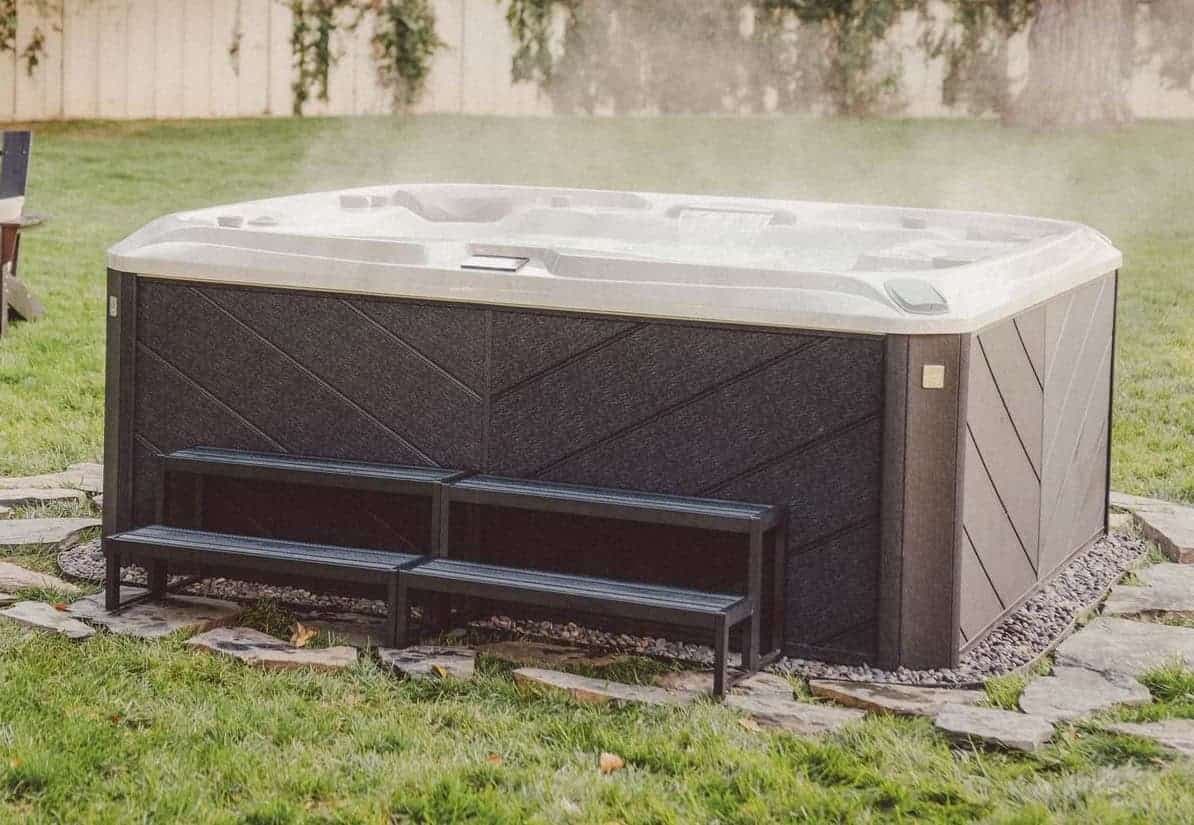 Hot tub with a matching step on a stone patio